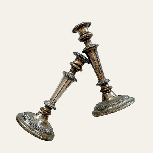 Pair of vintage silver candlesticks on a textured white background