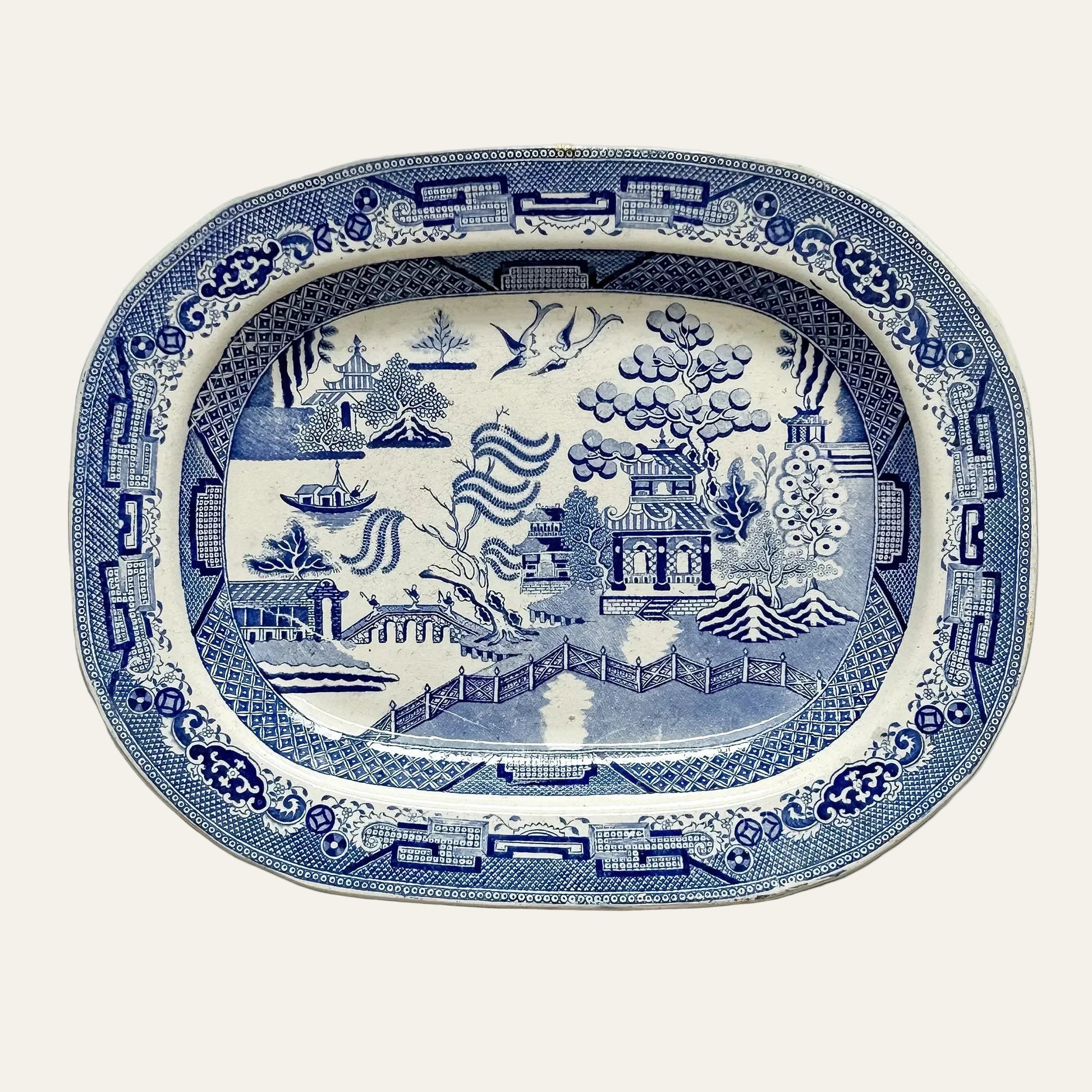Blue and white decorative platter with intricate patterns on a light gray background