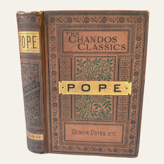 Vintage book titled 'The Chandos Classics' by Pope on a wooden surface.