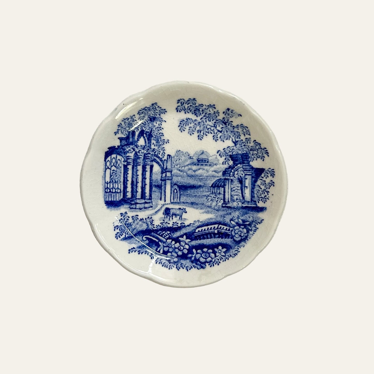 Ceramic plate with blue scenic design on a textured white surface