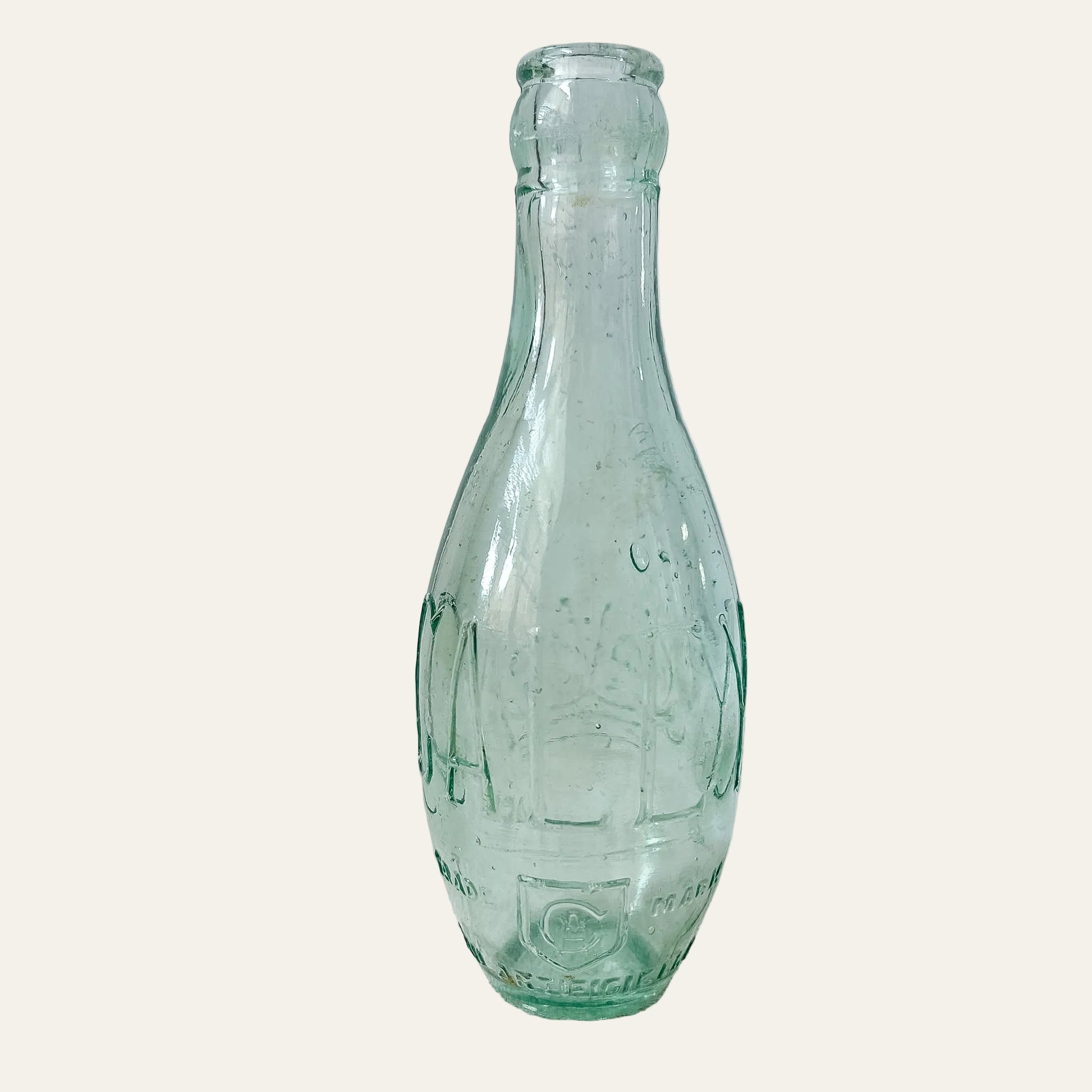 Vintage green glass bottle on a textured white surface
