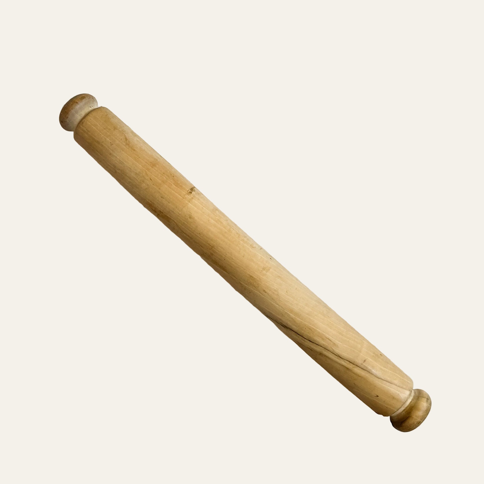 Wooden rolling pin on a light beige surface