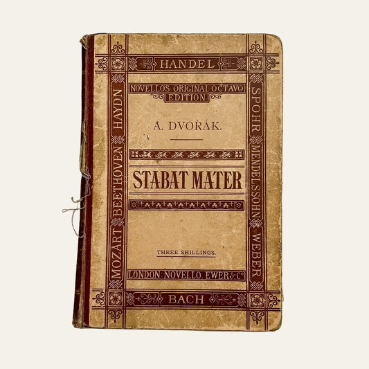 Vintage music score book titled 'Stabat Mater' on a textured white background